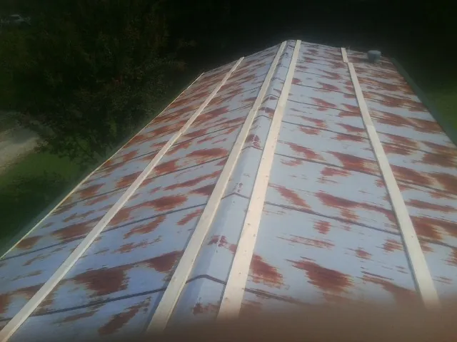 Rusted metal roof panels with new wood purlins before replacement — Storm Damage Roof Repair in Oyster Bay by Roofing Brothers