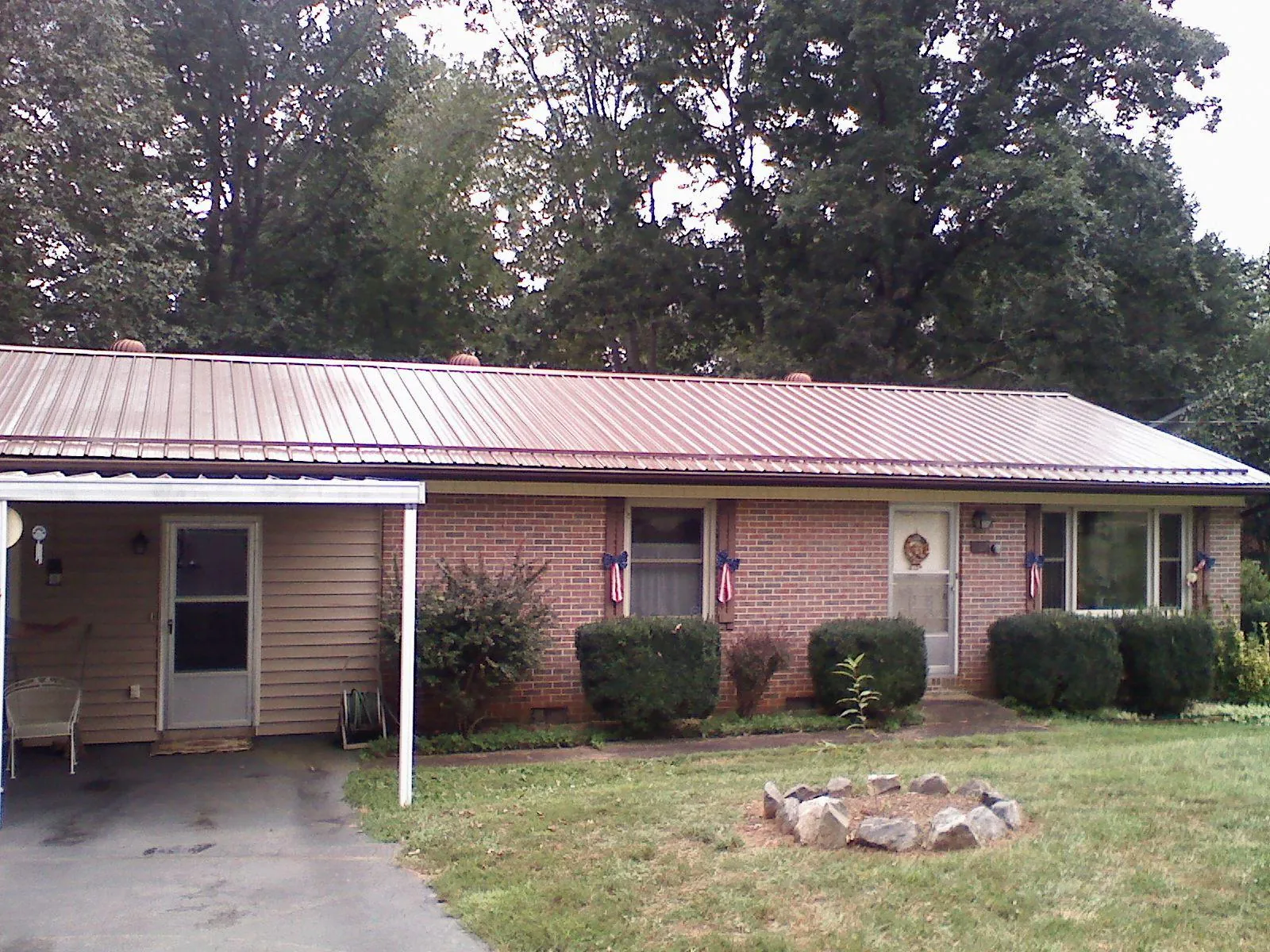Bronze metal roof and carport on a brick ranch home — Roof Repair work by our crew in Oyster Bay