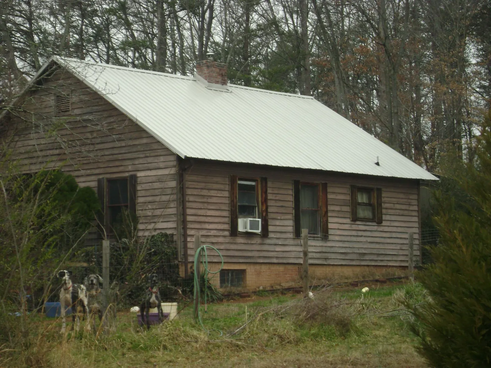 White metal roof on an old wood sided farmhouse, from a Metal Roof Installation job in Oyster Bay